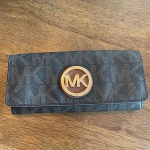 Michael Kors wallet with brown and tan accents and gold logo.